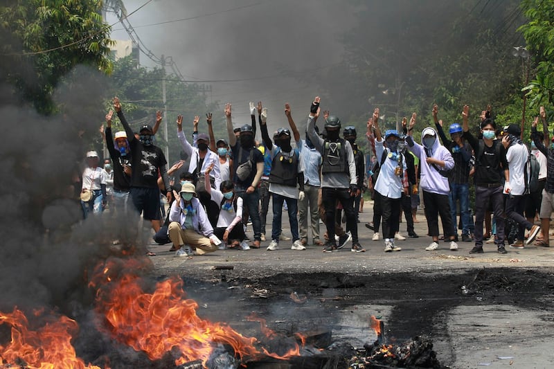 In this March 27, 2021 photo, anti-coup protesters gesture with a three-fingered salute, a symbol of resistance during a demonstration in Thaketa township Yangon, Myanmar. (AP Photo)