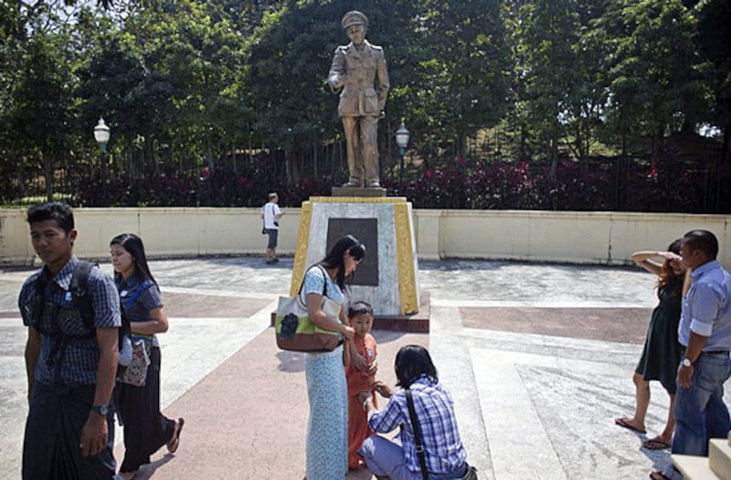 Visitors pass a statue of Myanmar's General Aung San, responsible for the country's independence from British rule and father of current State Counselor Aung San Suu Kyi, on the 101th anniversary of his birth, in Yangon, Feb. 13, 2016. 