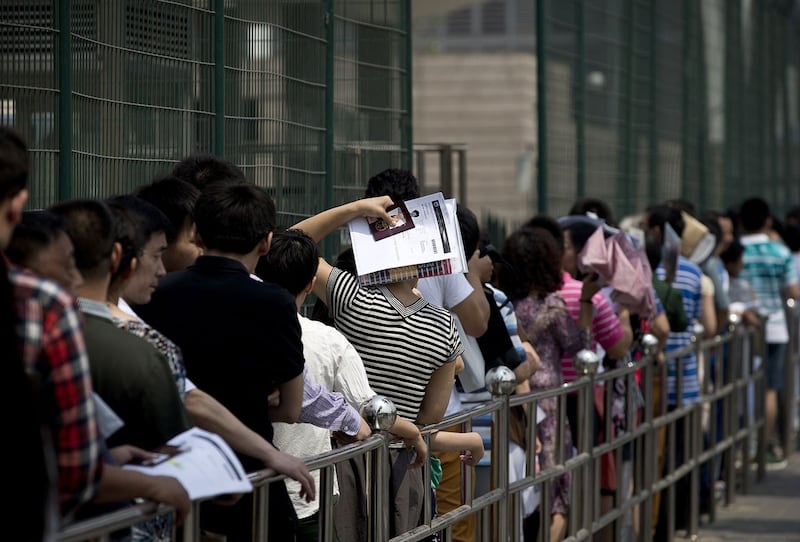 资料照：中国公民在北京美国大使馆外排队申请签证。（美联社）