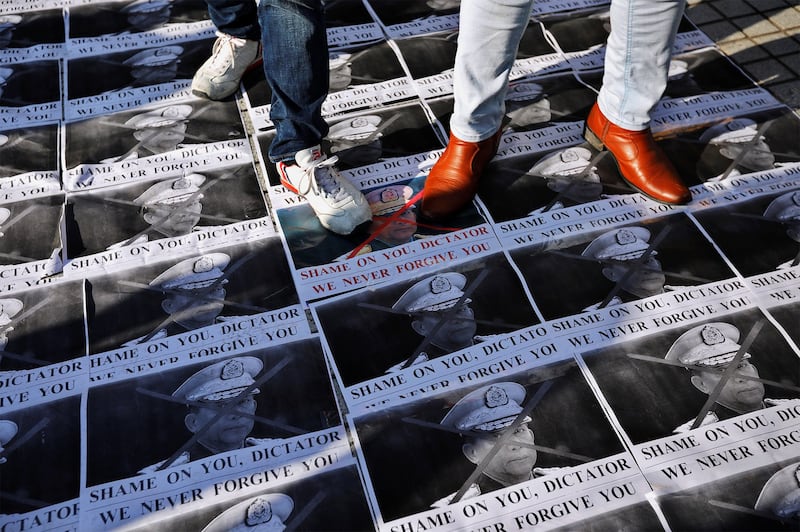 Protesters stand on pictures of Myanmar coup leader Min Aung Hlaing during a rally against military coup in Tokyo, Feb. 1, 2021. (Issei Kato/Reuters)