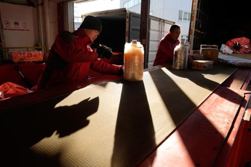 Workers sort parcels at a distribution center for e-commerce platform JD.com in Beijing, China, Nov. 11, 2023. (Ng Han Guan/AP)