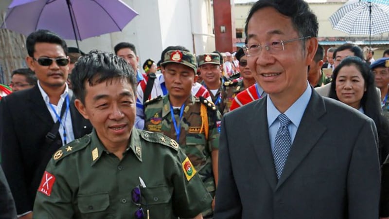 Myanmar ethnic rebel leader General Gun Maw (L) from the Kachin Independence Army walks with Chinese special envoy Sun Guoxiang (R) as representatives of various Myanmar ethnic rebel groups arrive for the opening of a conference in Mai Ja Yang, northern Myanmar's Kachin state. July 26, 2016.