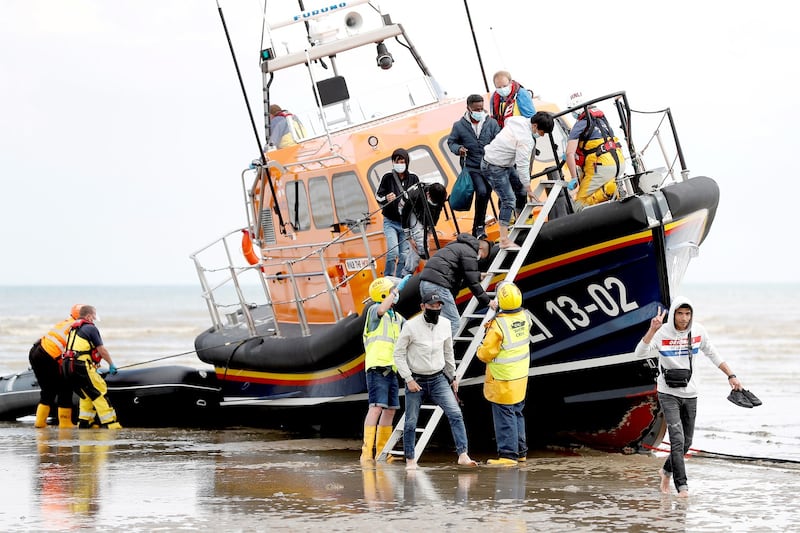 Migrants from nations that include Vietnam leave an RNLI vessel after being rescued in the English Channel, following their departure from northern France, in Dungeness, Britain, August 4, 2021. Credit: Reuters