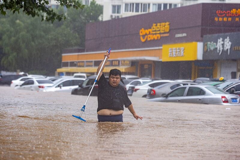 2023年8月1日，一名男子走在被洪水淹没的北京街道上。（路透社）