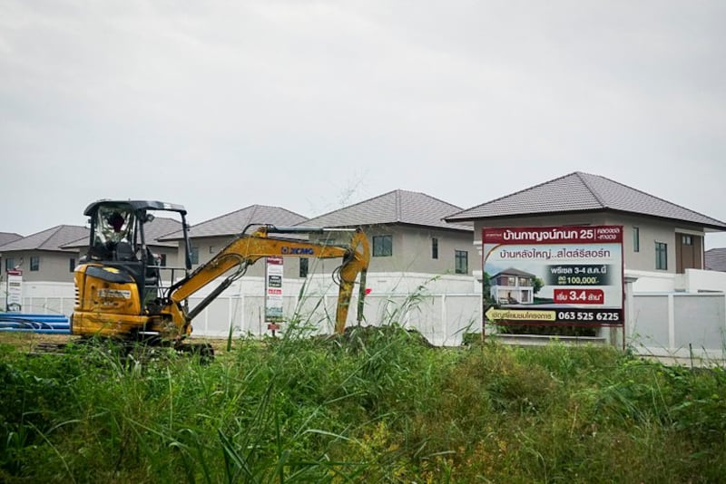 A construction vehicle sits at a housing development where many Chinese residents live, near a sign advertising available properties in Hang Dong district, Chiang Mai province, Nov. 10, 2024.