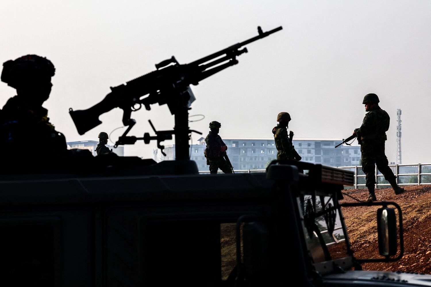 Military personnel stand guard as hundreds of refugees crossed over the river frontier between Myanmar and Thailand in Mae Sot, Tak province, Thailand, April 2024.