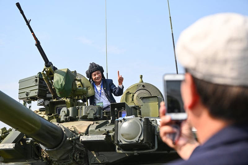 A man poses for photo on top of a Russian made tank during the Vietnam 2024 International Defense Expo in Hanoi on December 19, 2024.