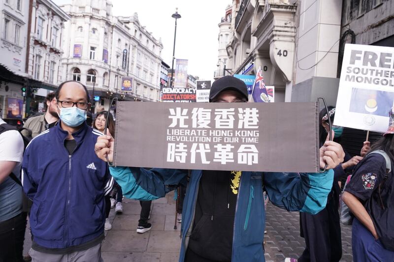 有港人手持写着“光复香港，时代革命”的标语参与游行。 （石头摄）