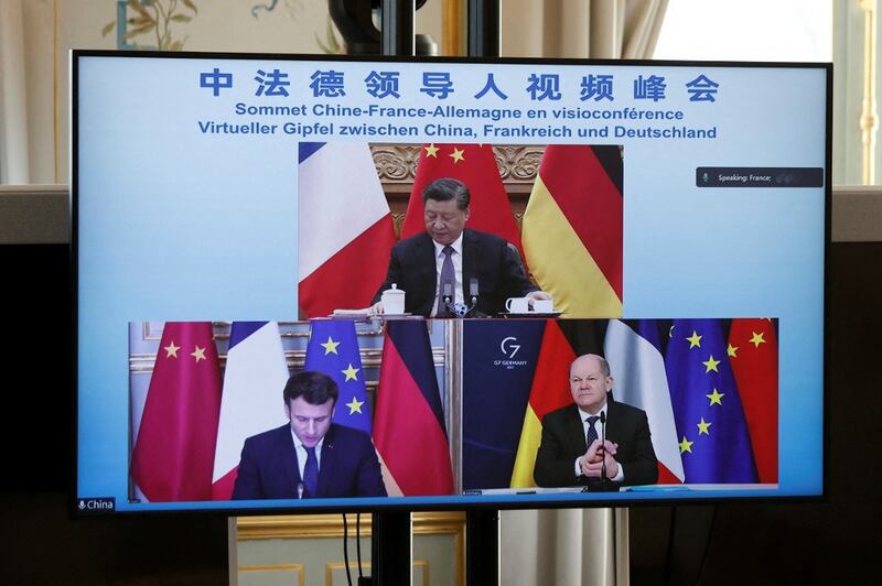 A video screen displays French President Emmanuel Macron (bottom, left), German Chancellor Olaf Scholz (bottom, right) and Chinese President Xi Jinping (top) attending a video-conference to discuss the Ukraine crisis, at the Elysee Palace in Paris, March 8, 2022. Credit: AFP