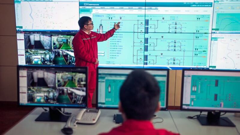 A worker from Chinese oil giant Sinopec shows control panels to journalists in Zangangzhen, northern China's Heibei province, Feb. 23, 2017.