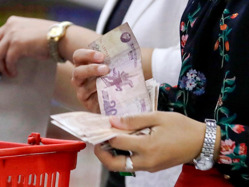 A North Korean hands money to a supermarket cashier in Pyongyang, North Korea, on Sept. 12, 2018.