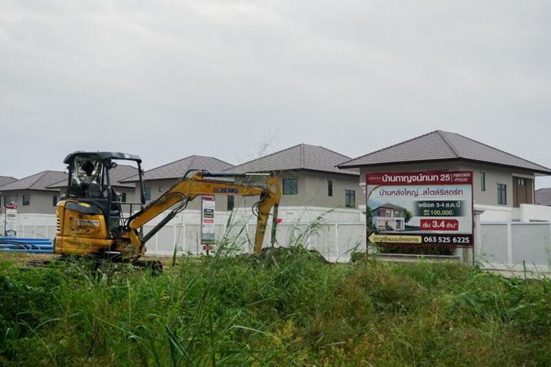 2024年11月10日，一辆建筑车辆停在一个有许多中国居民居住的住宅区附近，旁边是一个广告空置房源的标牌，位于泰国清迈省杭东区。（Kanokphorn Janploy/BenarNews）