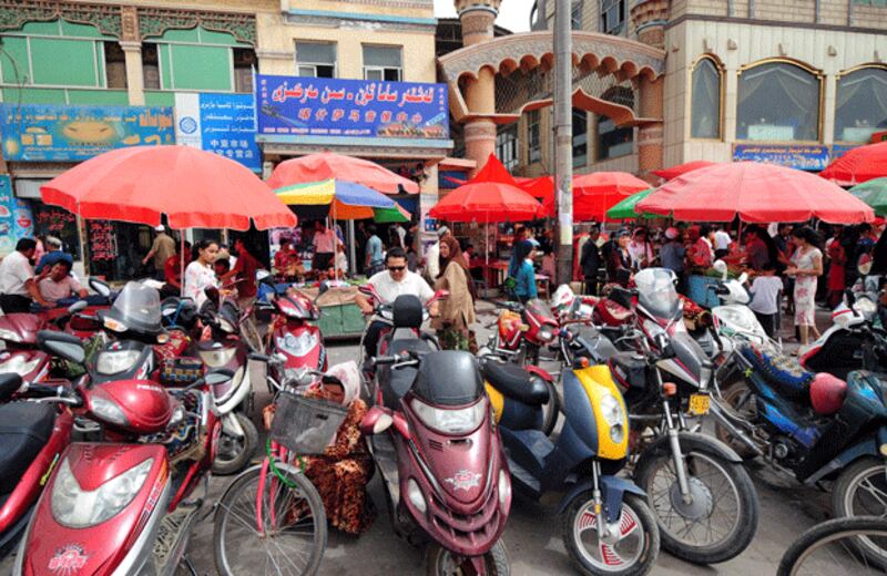 Motorized scooters stand outside the crowded Sunday Bazaar in Kashgar, a Silk Road trading center in northwestern China's Xinjiang region, June 15, 2008. AFP