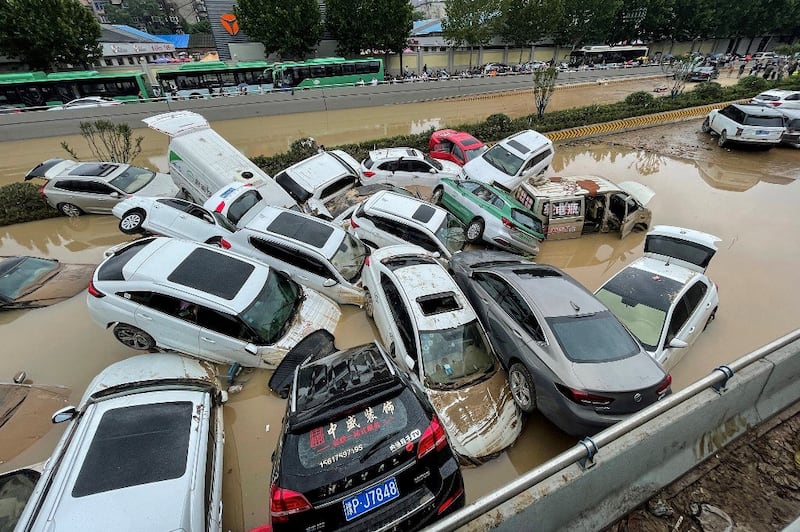 Cars sit in floodwaters after heavy rains hit the city of Zhengzhou in China's central Henan province on July 21, 2021. (Photo by STR / AFP)