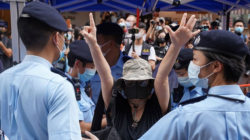 2021年7月1日，是香港主权移交24周年，兼中国共产党成立100周年，铜锣湾警方拒绝允许举行抗议集会后，一名妇女在铜锣湾高举象征“五大诉求，缺 一不可”的手势。（路透社）