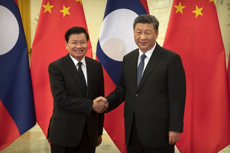 Laos Prime Minister Thongloun Sisoulith (L) shakes hands with China's President Xi Jinping (R) before a meeting at the Great Hall of the People in Beijing Jan. 6, 2020.