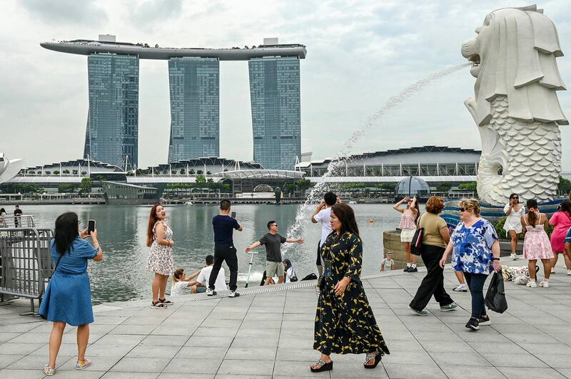 People are seen near the Merlion statue in front of the Marina Bay Sands resort in Singapore on Dec. 2, 2024.