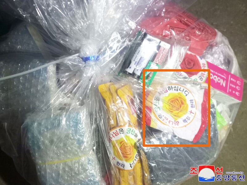 Esta fotografía, publicada por la Agencia Central de Noticias de Corea del Norte, estatal, muestra una bolsa con alimentos, baterías y medicamentos, con pegatinas que confirman que un grupo en Corea del Sur lanzó globos hacia el Norte identificados como propios.