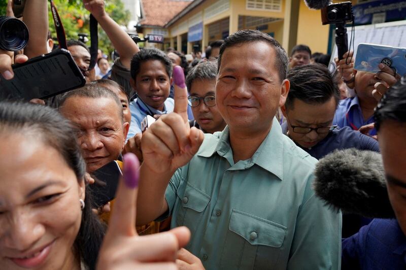 Hun Manet, commander of the Royal Cambodian Army and eldest son of Prime Minister Hun Sen, shows his finger after he casts his vote at a polling station in Phnom Penh on July 23, 2023. (Photo by -STR / AFP)