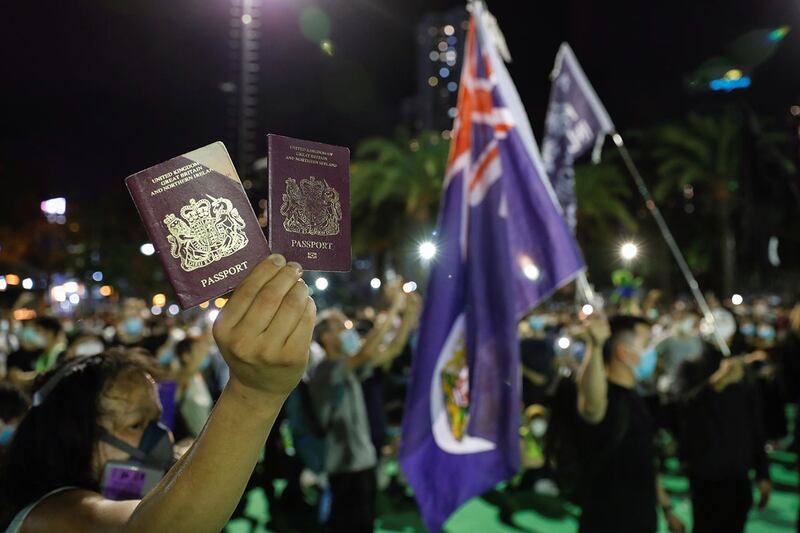 2020 年 6 月 4 日，一名香港示威者手举英国国民海外护照(BNO)。（路透社）