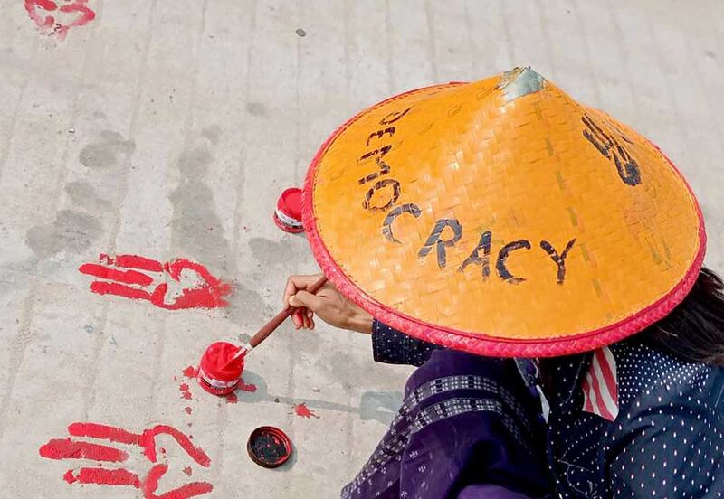 A protester paints the three-finger salute of the resistance as part of the "Bleeding Strike" demonstration Wednesday in Shwebo in Myanmar's Sagaing region. (AFP/Anonymous source)