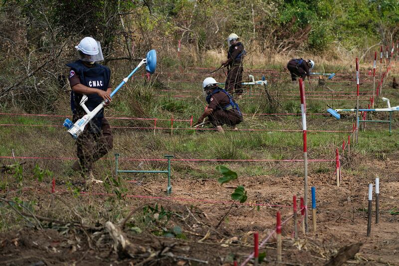 Staffers with the Cambodia Mine Action Center clear a minefield in Preytotoeung village, Battambang province, Cambodia, Jan. 19, 2023.