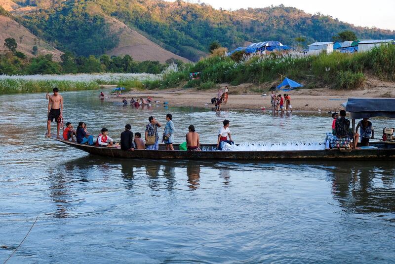 Myanmar refugees ride on a boat after receiving aid in Mae Sot, Thailand, Jan. 4, 2022. Credit: Reuters