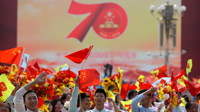 中国国庆70周年上的学生们在挥舞国旗。（美联社）