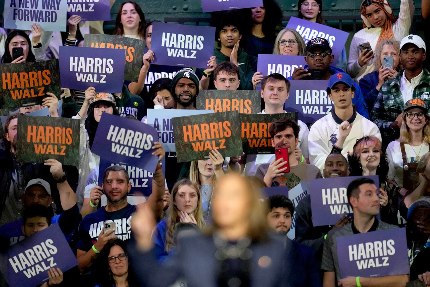 Supporters hold signs as Democratic presidential nominee Vice President Kamala Harris speaks at a rally at Michigan State University, Nov. 3, 2024, in East Lansing, Michigan.