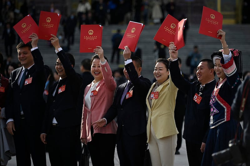 A group of delegates poses for a picture after the closing session of the 14th National People's Congress at the Great Hall of the People in Beijing on March 11, 2024. (Wang Zhao/AFP)