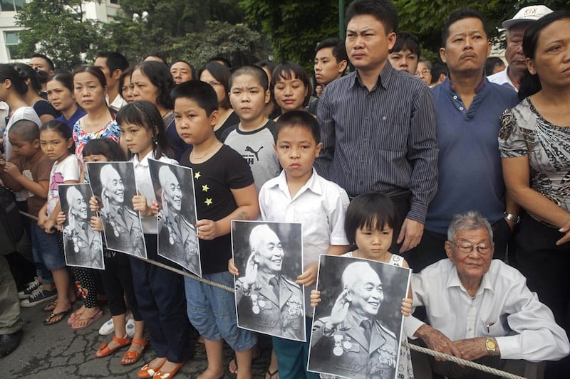 Hình minh họa. Người dân cầm ảnh Đại tướng Võ Nguyên Giáp ở Hà Nội khi xe tang đi qua hôm 13/10/2013