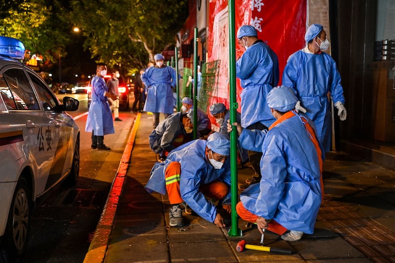 Workers erect fencing around a neighborhood in lockdown in Shanghai's Changning district, after new COVID-19 cases were reported, Oct. 7, 2022. Credit: AFP