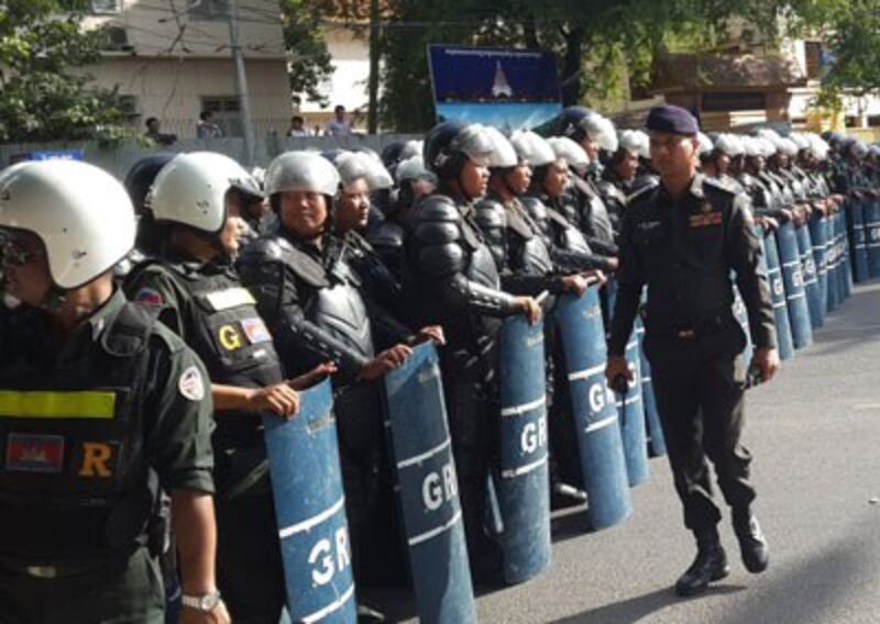 Riot police armed with batons and shields prepare to block marching protesters in Phnom Penh, May 29, 2014. Credit: RFA