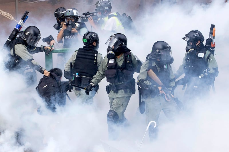 Police in riot gear move through a cloud of smoke as they detain a protester at the Hong Kong Polytechnic University in Hong Kong, Nov. 18, 2019. (Ng Han Guan/AP)