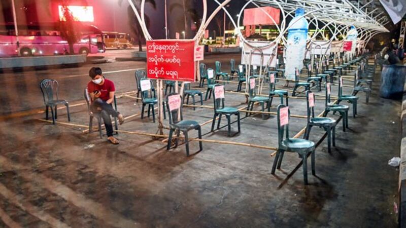 A man wearing a face mask sits on a chair set apart from others as a preventive measure against the spread of the coronavirus at a Yangon-Mandalay highway restaurant in central Myanmar's Bago region, April 3, 2020.