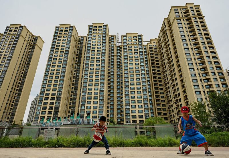 Children play basketball in front of a housing complex by Chinese property developer Evergrande in Beijing, July 28, 2022. Credit: AFP