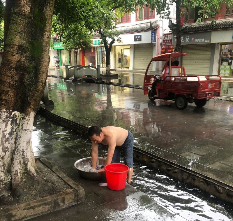 房子遭停水停电，陈云飞要用街上沟里的水洗衣服。（推特图片，拍摄日期不详）