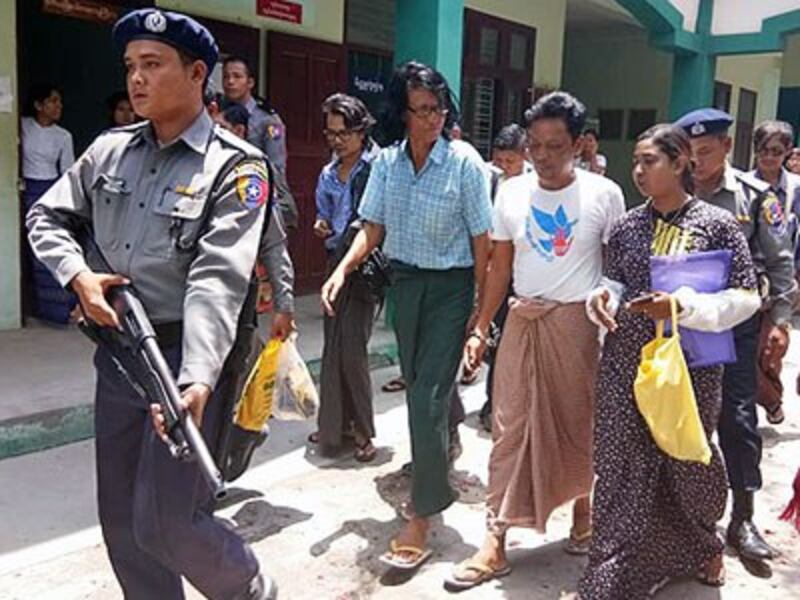 Antiwar activist Aung Hmine San is escorted to court by an armed guard to face charges for violating Article 19 of Myanmar's Peaceful Assembly and Procession Law in central Myanmar's Mandalay, May 9, 2018.