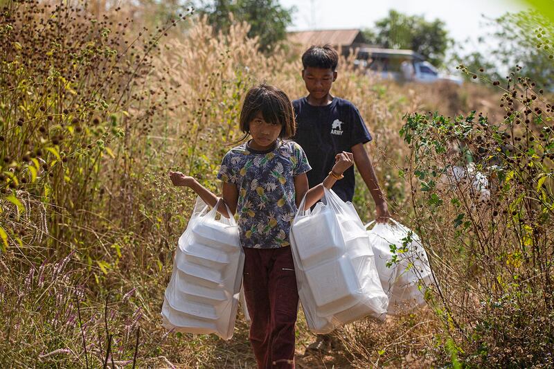 Myanmar refugees, who fled a surge in violence as the military cracks down on rebel groups, with food aid, Jan. 15, 2022, on the Thai border in Thailand's Mae Sot district. (AFP)