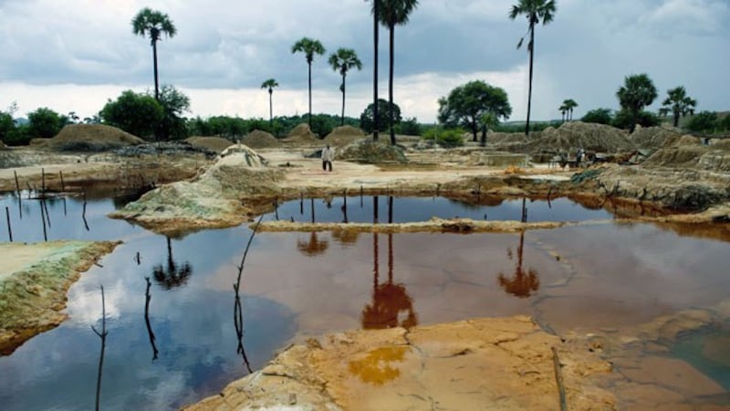 A Myanmar worker walks by pools in a mining waste dump area in Monywa, northwestern Myanmar's Sagaing region, in a file photo.