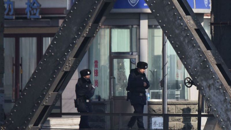 资料图片：位于中国辽宁省东北部边境城市丹东市中朝边境横跨鸭绿江的大桥上， 2019年2月23日有中共警察在海关检查站前巡逻。（法新社） 