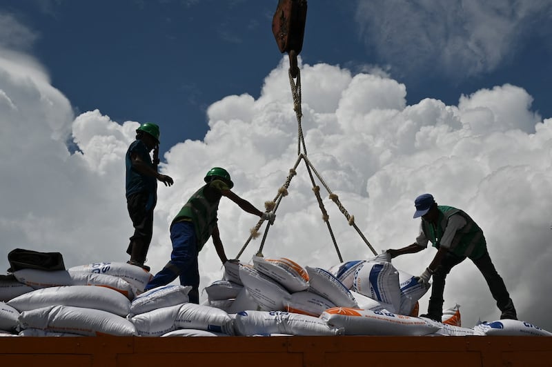 Workers unload rice imported from Vietnam by the Indonesian Logistics Bureau at the port of Malahayati, in Indonesia's Aceh province, Oct. 11, 2023. Credit: Chaideer Mahyuddin/AFP