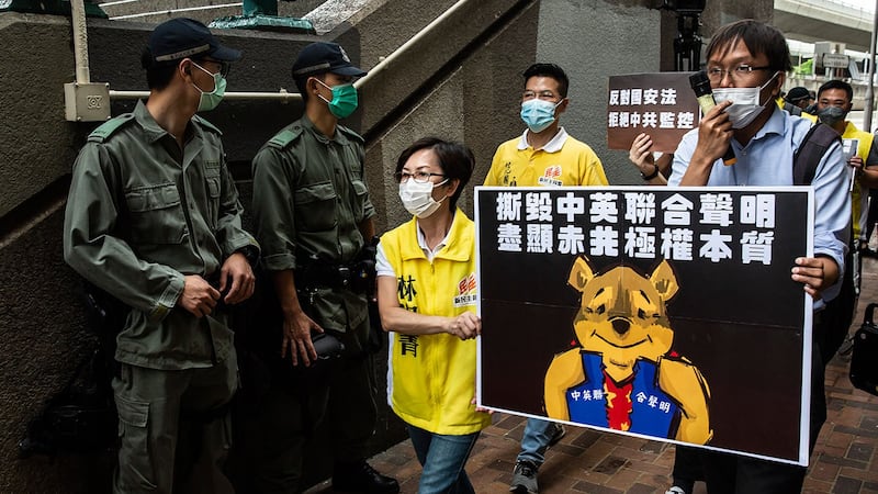 资料图片：2020 年 5 月 24 日，民主活动人士手持代表习近平的小熊维尼牌，前往香港中联办，抗议拟议新国安法。 （法新社）