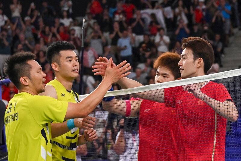 China's Wang Chang and Liang Weikeng congratulate Taiwan's Wang Chi-lin and Lee Yang after the men's doubles badminton final match during the Paris 2024 Olympic Games at Porte de la Chapelle Arena in Paris Aug. 4, 2024. (Arun Sankar/AFP)