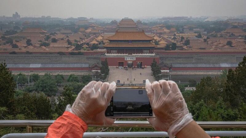 陈冠中的小说探讨北京城变迁，正史、野史虚实交错。图为民众从景山顶上俯瞰紫禁城，照片左上方远处为北京饭店。(美联社)