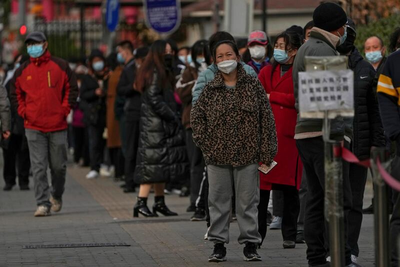 民众2022年11月27日在北京一检测点排队准备检测核酸（美联社图片）