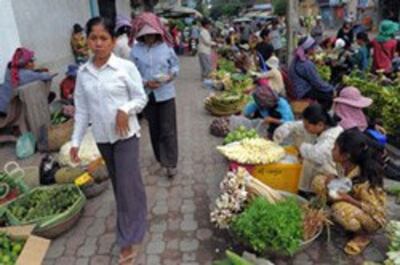 Một phụ nữ Campuchia đi trong khu chợ họp dọc đường phố ở Phnom Penh ngày 02 tháng 9 năm 2010. AFP PHOTO / TANG CHHIN SOTHY.