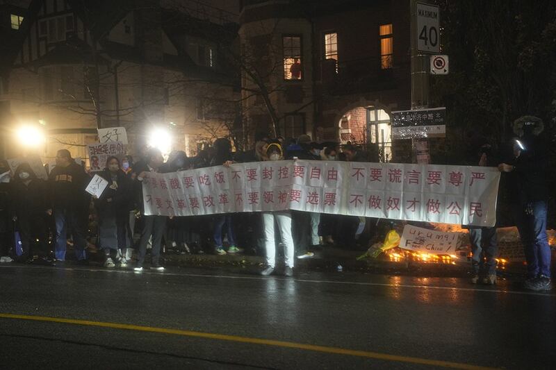 数百中国留学生齐聚多伦多街头，拿着北京勇士彭立发当时在四通桥挂出的字句。　　　（公民会提供）