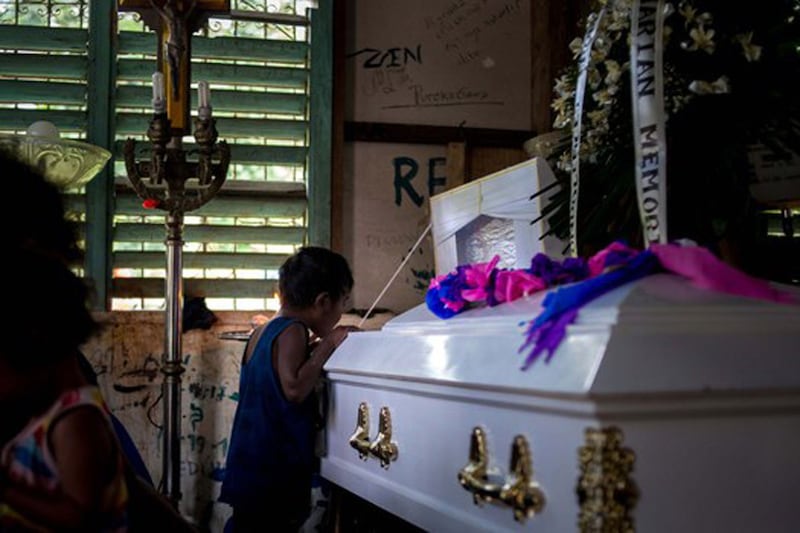 Randy dela Cruz's son peeks into his father's coffin, March 16, 2021. Tribal communities have protested displacement due to the Kaliwa dam project, and have faced sometimes violent reprisals, including the killing of two Dumagat community members during an “anti-communist” crackdown. Credit: BenarNews