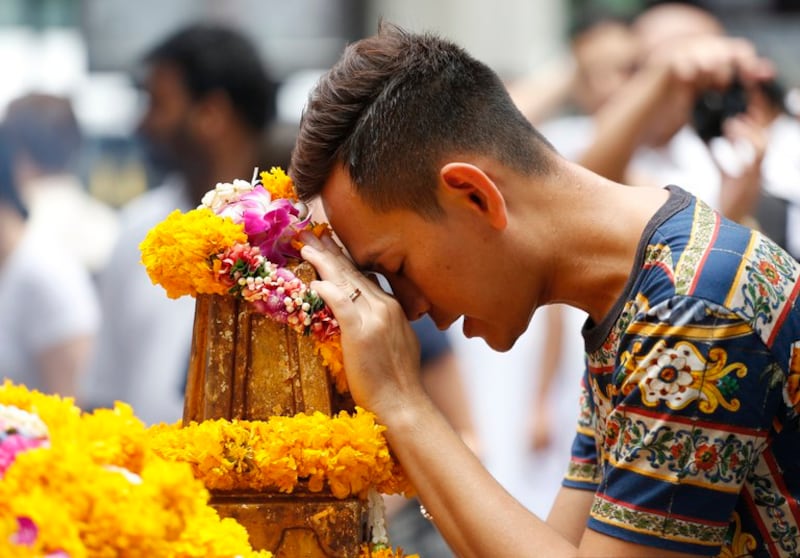 A man prays at the Erawan Shrine at the Rajprasong intersection, the scene of a deadly bombing a week earlier in Bangkok, Aug. 24, 2015. (Sakchai Lalit/AP)